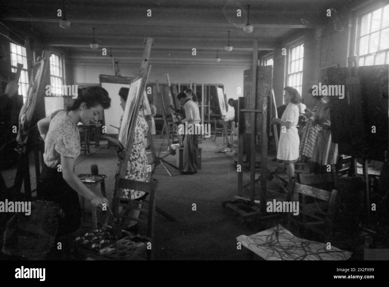 FROM THE SERVICES TO SCHOOLMASTERING: RE-TRAINING AT GOLDSMITH'S COLLEGE, LONDON UNIVERSITY, NOTTINGHAM, ENGLAND, 1944 - Two of the 28 ex-servicemen training to be teachers at Goldsmiths College (based at Nottingham University since the outbreak of war) are training to have art as their main subject. Here they can be seen taking part in an art class at Nottingham University. The original caption makes much of the fact that most of the Nottingham art students are women : 'as the photographer clicks the shutter one [of the men] says 'This'll make the boys jealous'' Stock Photo