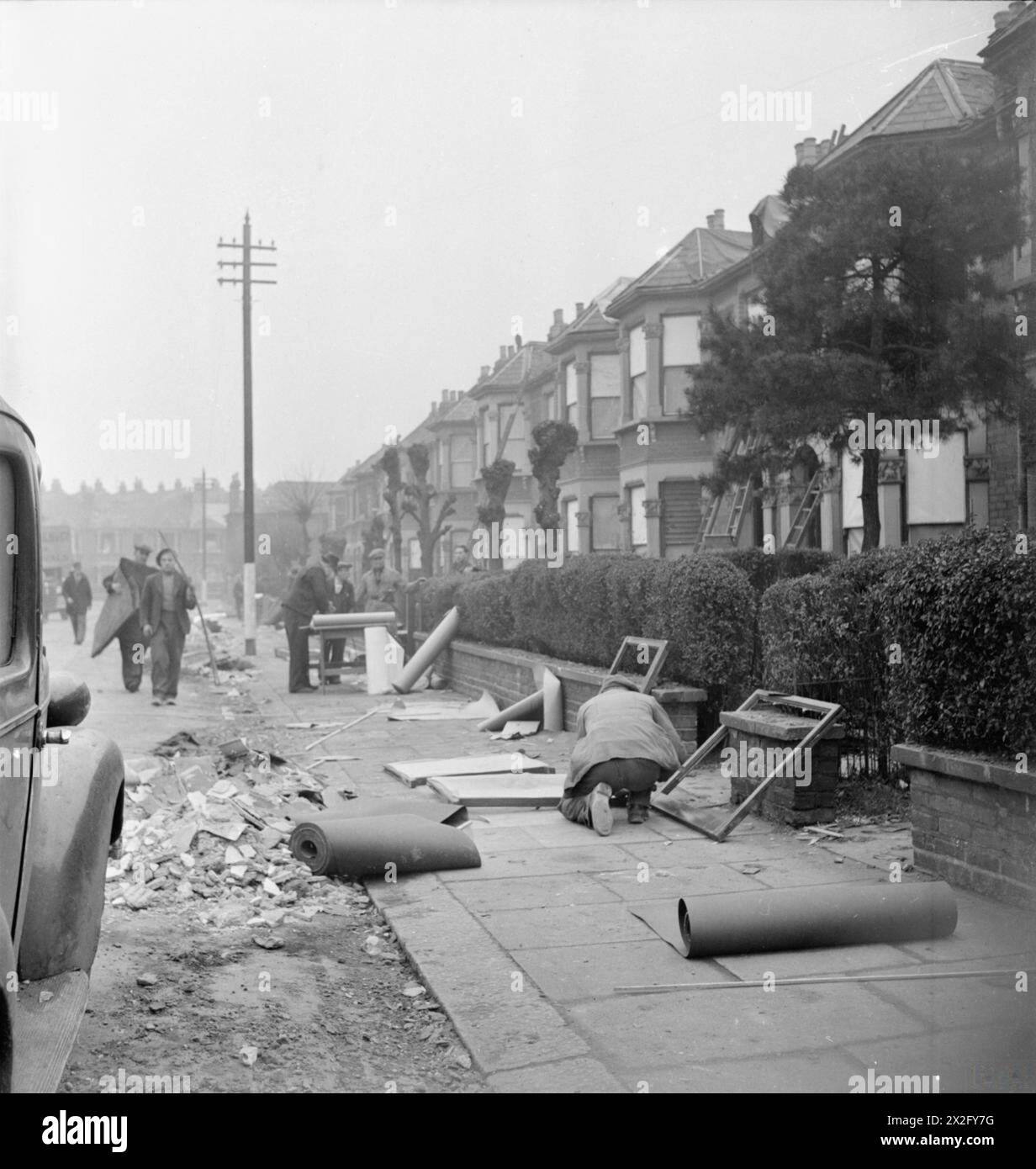 Workmen perform temporary 'First Aid' repairs to bomb-damaged houses in ...
