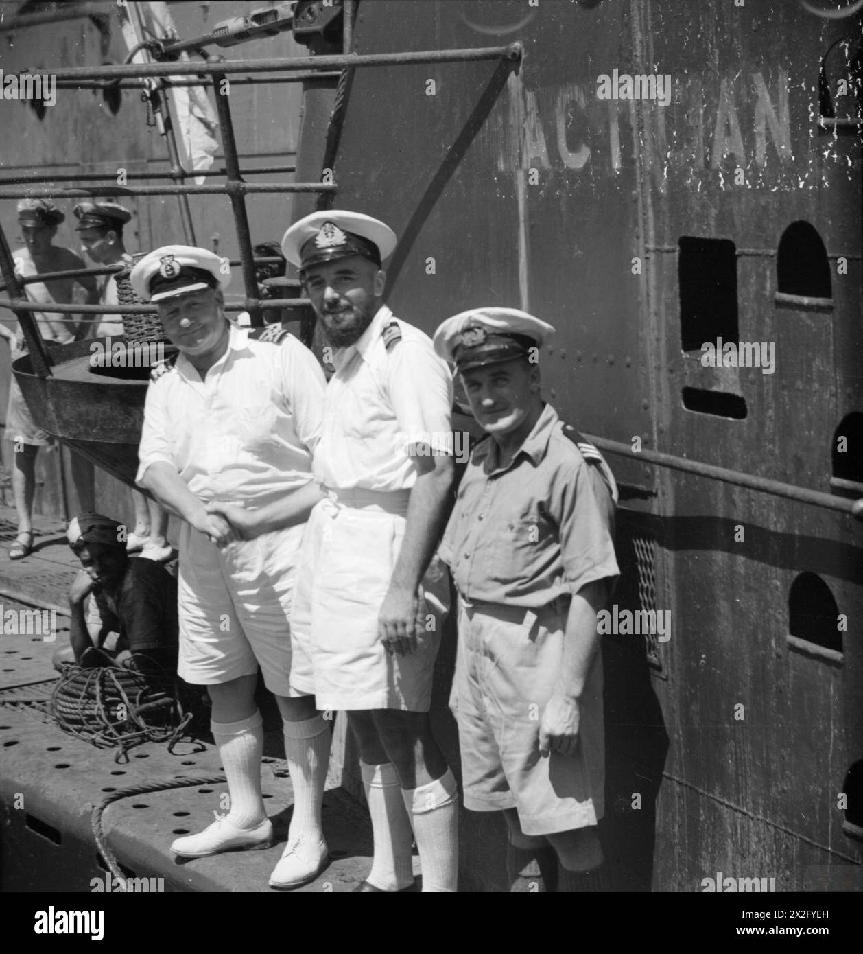 TACTICIANS MEET. 19 MARCH 1944, COLOMBO, CEYLON. LIEUTENANT COMMANDER ANTHONY F COLLETT, DSC, RN, COMMANDING OFFICER OF HM SUBMARINE TACTICIAN WITH TWO MERCHANT NAVY OFFICERS OF THE SS TACTICIAN. - Lieut Cdr A F Collett, DSC, RN, (centre) welcoming Captain Harriman (left) and Mr L J Williams (right) of the SS TACTICIAN, onto his submarine HMS TACTICIAN Stock Photo