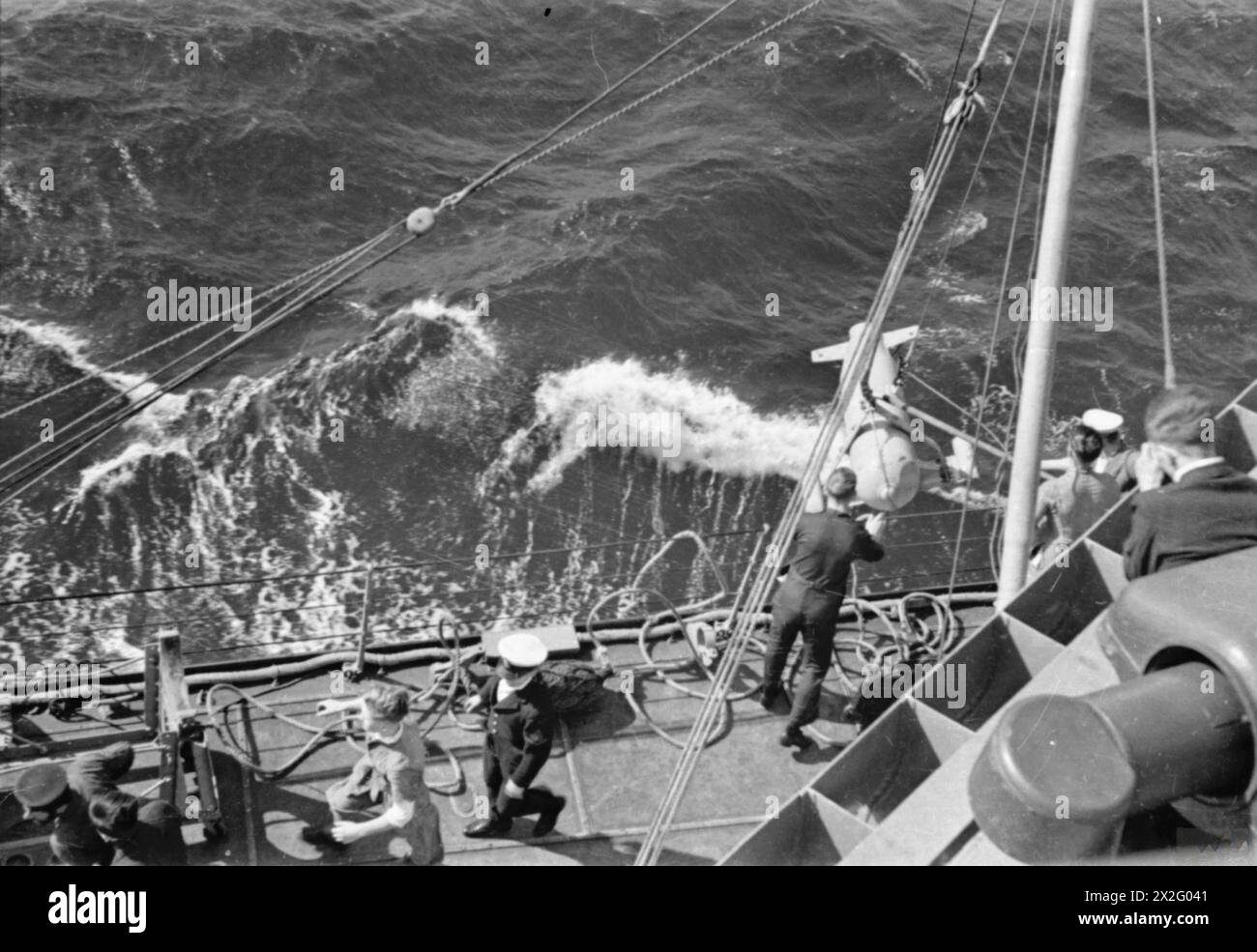 Crew aboard HMS Sheffield hoist in paravanes while escorting a British ...