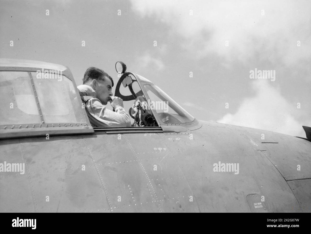 FLEET AIR ARM RAID ON PADANG. 23 AND 24 AUGUST 1944, ON BOARD HMS INDOMITABLE AT SEA. A CARRIER-BORNE FLEET AIR ARM ATTACK, SUPPORTED BY ALLIED UNITS OF THE EASTERN FLEET, WAS CARRIED OUT ON 24 AUGUST 1944 AGAINST THE LARGE INDAROENG CEMENT MANUFACTURING PLANT NEAR PADANG, ON THE WEST COAST OF SUMATRA. AND ALSO AGAINST EMMAHAVEN, THE PORT OF PADANG. - Sub Lieut (A) Edwin Hawkins, of Cambridge, the pilot of a Hellcat fighter, waiting to take off Stock Photo