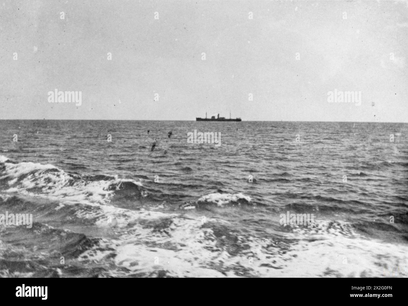 THE INTERCEPTION AND SCUTTLING OF THE GERMAN SS IDARWALD. 8 AND 9 DECEMBER 1940, ON BOARD A BRITISH WARSHIP OFF CUBA. THE GERMAN HAMBURG-AMERIKA FREIGHTER IDARWALD WAS INTERCEPTED BY A PATROLLING BRITISH WARSHIP OFF CUBA. THE GERMAN CREW AT ONCE SCUTTLED THEIR SHIP, SET FIRE TO HER, AND TOOK TO THEIR BOATS. THE BRITISH SHIP FOUGHT THE FIRE AND TOOK THE IDARWALD IN TOW, BUT SHE HAD TO BE CAST OFF SHORTLY THEREAFTER AND SANK. - The British warship approaches the IDARWALD Stock Photo