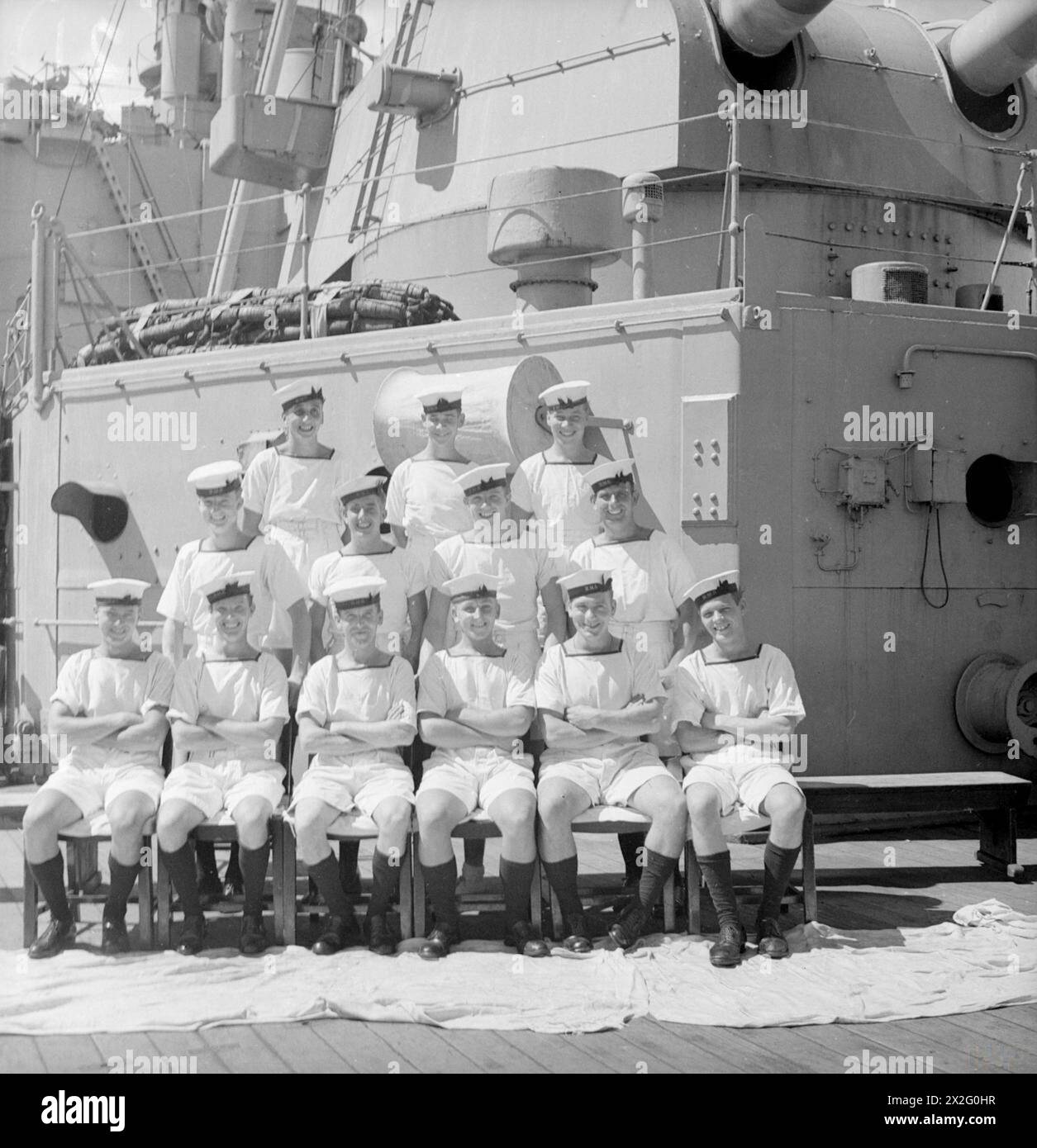MEN OF THE HMS SUFFOLK, A CRUISER SERVING WITH ADMIRAL JAMES SOMERVILLE'S EASTERN FLEET. 12 DECEMBER 1943, TRINCOMALEE. THE MEN ARE DIVIDED INTO GROUPS BY TOWN AND/OR DISTRICT. - East London group. Front row, left to right: AB C Brown; AB R Sidwell; Stoker W West; AB E Chamberlain; AB C Purton; L/Sea T McNally. Second row, left to right; AB E Challenger; AB W Tatman; AB F Stemp; AB S Tuff. Third row, left to right: AB A Meddings; O/Sea L Howard; AB W Legg Stock Photo