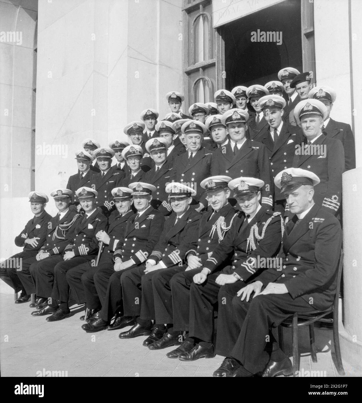 REAR ADMIRAL MORGAN AND HIS STAFF. DECEMBER 1944, TARANTO. REAR ADMIRAL C E MORGAN, DSO, FLAG OFFICER TARANTO AND ADRIATIC AND FOR LIAISON WITH THE ITALIANS, WITH HIS STAFF. - Left to right: First row: Chaplain W D Dinnis; Lieut Cdr L White, USN; Captain C H Duffett, DSO, RN; Commodore J Powell, DSO; Rear Admiral C E Morgan, DSO; Captain R I Money, RN; Lieut Cdr (S) G H L Kitson, RN; Lieut J W Kentish, RNVR; Chaplain W Devine, MC. Second row: Commander A Morrison, RN; Commander A G Orr-Ewing, RNVR; Commander R F Nagle, RNVR; Commander T H Trueman, RNVR; Commander R B Bodily, RN; Commander (E) Stock Photo
