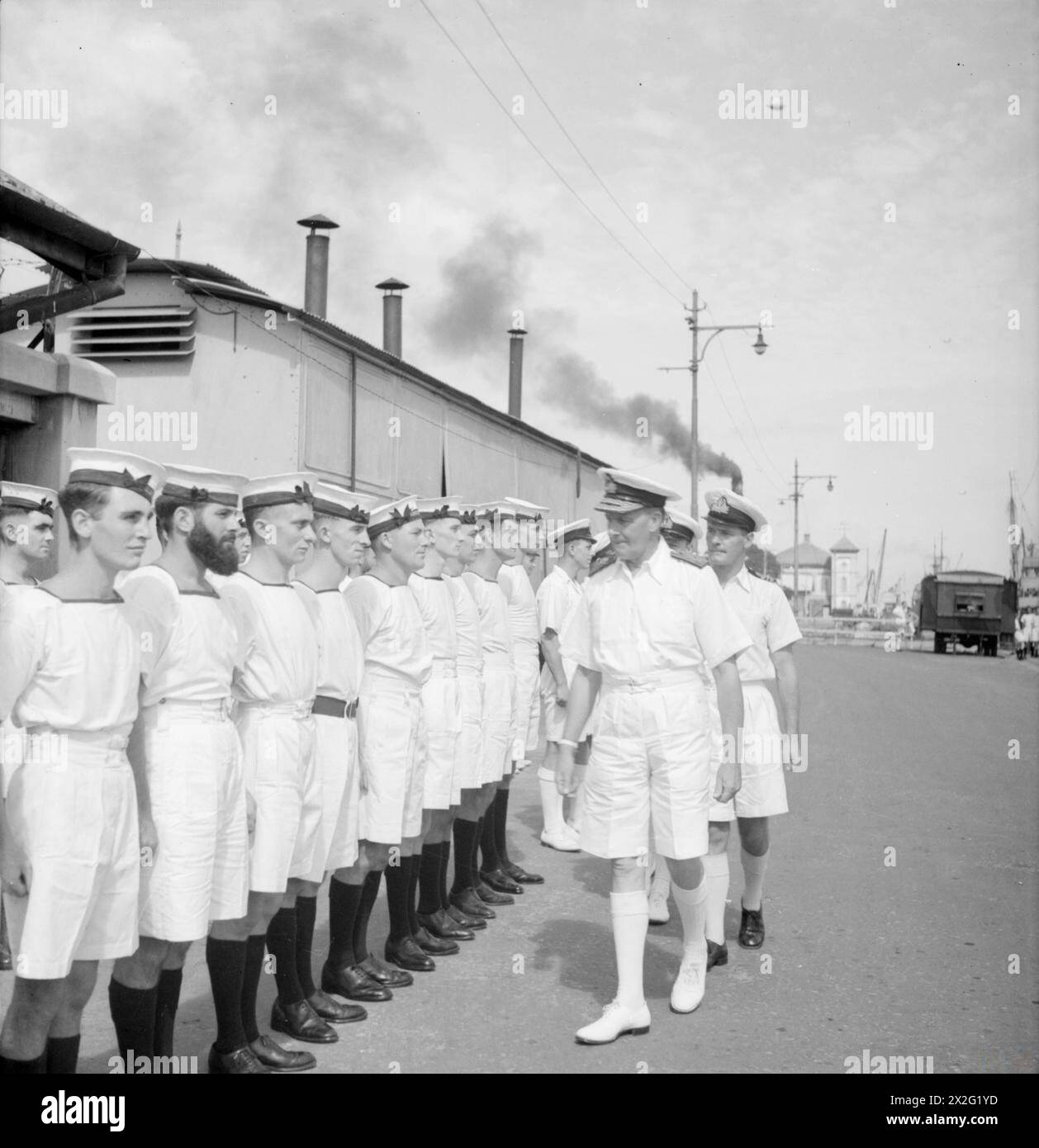 TALLY HO LIMPS HOME. 9 MARCH 1944, COLOMBO, CEYLON. THE RETURN TO PORT OF THE SUBMARINE TALLY HO AFTER A SUCCESSFUL PATROL DURING WHICH SHE SUSTAINED DAMAGE WHEN A JAPANESE TORPEDO BOAT CRASHED INTO HER. - C in C Eastern Fleet, Admiral Sir James Somerville, KCB, KBE, DSO, inspects members of the TALLY HO's crew. Left to right ERA J M Powell, DSM, of Penarth; AB Kenneth Lockyer, of Brixton; L/Sea Albert Sutton, of Birmingham; L/Stoker W E Betts, of Putney; AB D A Harvey, of Blythe; L/Sea S Hawkey, DSM, of Liverpool; Stoker W Illsley, of Waterloo, London; L/Stoker G French, of Bexley Heath; AB C Stock Photo