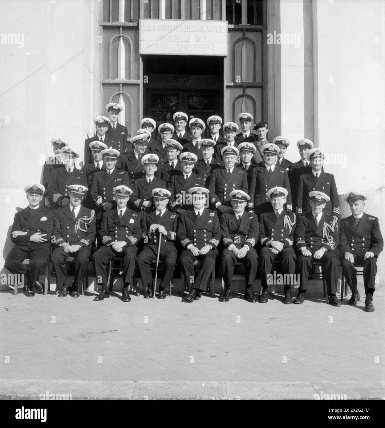 REAR ADMIRAL MORGAN AND HIS STAFF. DECEMBER 1944, TARANTO. REAR ADMIRAL C E MORGAN, DSO, FLAG OFFICER TARANTO AND ADRIATIC AND FOR LIAISON WITH THE ITALIANS, WITH HIS STAFF. - Left to right: First row: Chaplain W D Dinnis; Lieut Cdr L White, USN; Captain C H Duffett, DSO, RN; Commodore J Powell, DSO; Rear Admiral C E Morgan, DSO; Captain R I Money, RN; Lieut Cdr (S) G H L Kitson, RN; Lieut J W Kentish, RNVR; Chaplain W Devine, MC. Second row: Commander A Morrison, RN; Commander A G Orr-Ewing, RNVR; Commander R F Nagle, RNVR; Commander T H Trueman, RNVR; Commander R B Bodily, RN; Commander (E) Stock Photo