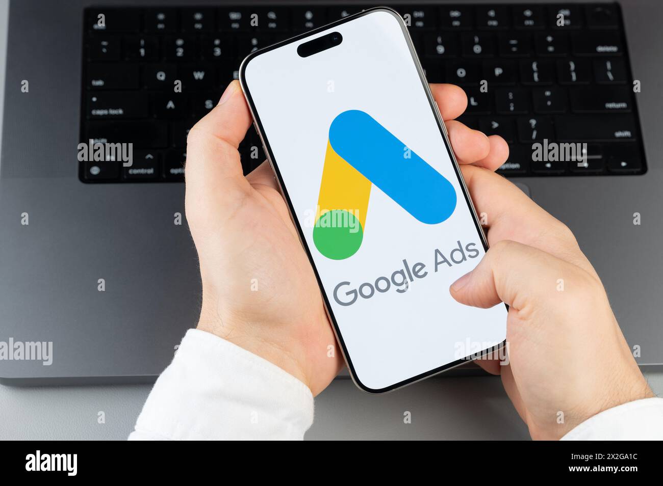 New York, USA - April 6, 2024: Popular Google ads mobile app on smartphone screen in hands on laptop keyboard background Stock Photo