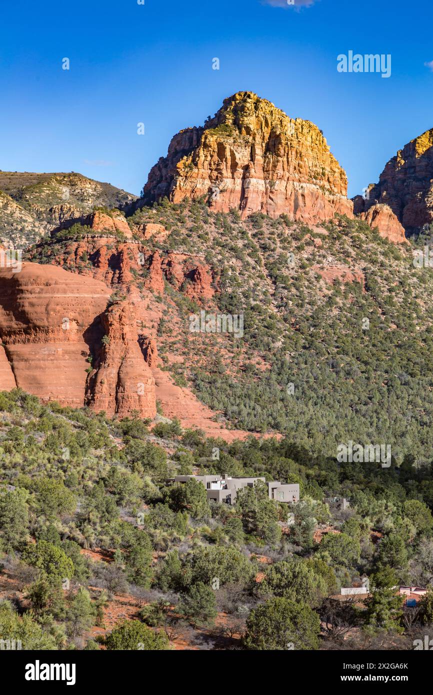 Mountainside home beneath red rock sandstone formations of Sedona, Arizona Stock Photo
