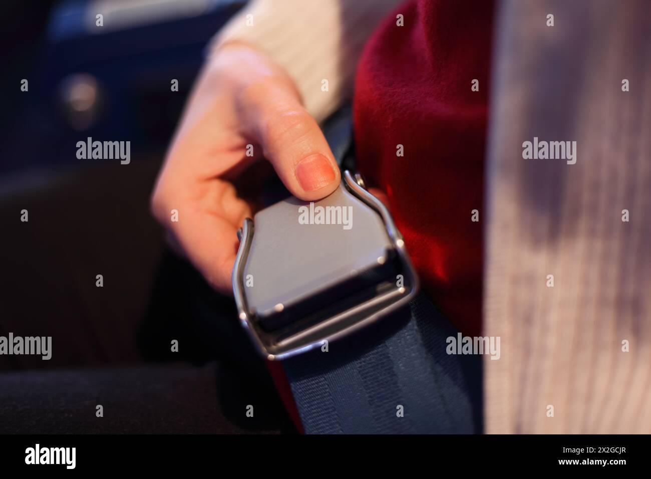 Female hand with a lock of the seat belt, focus on the thumb, shallow depth of focus. Stock Photo