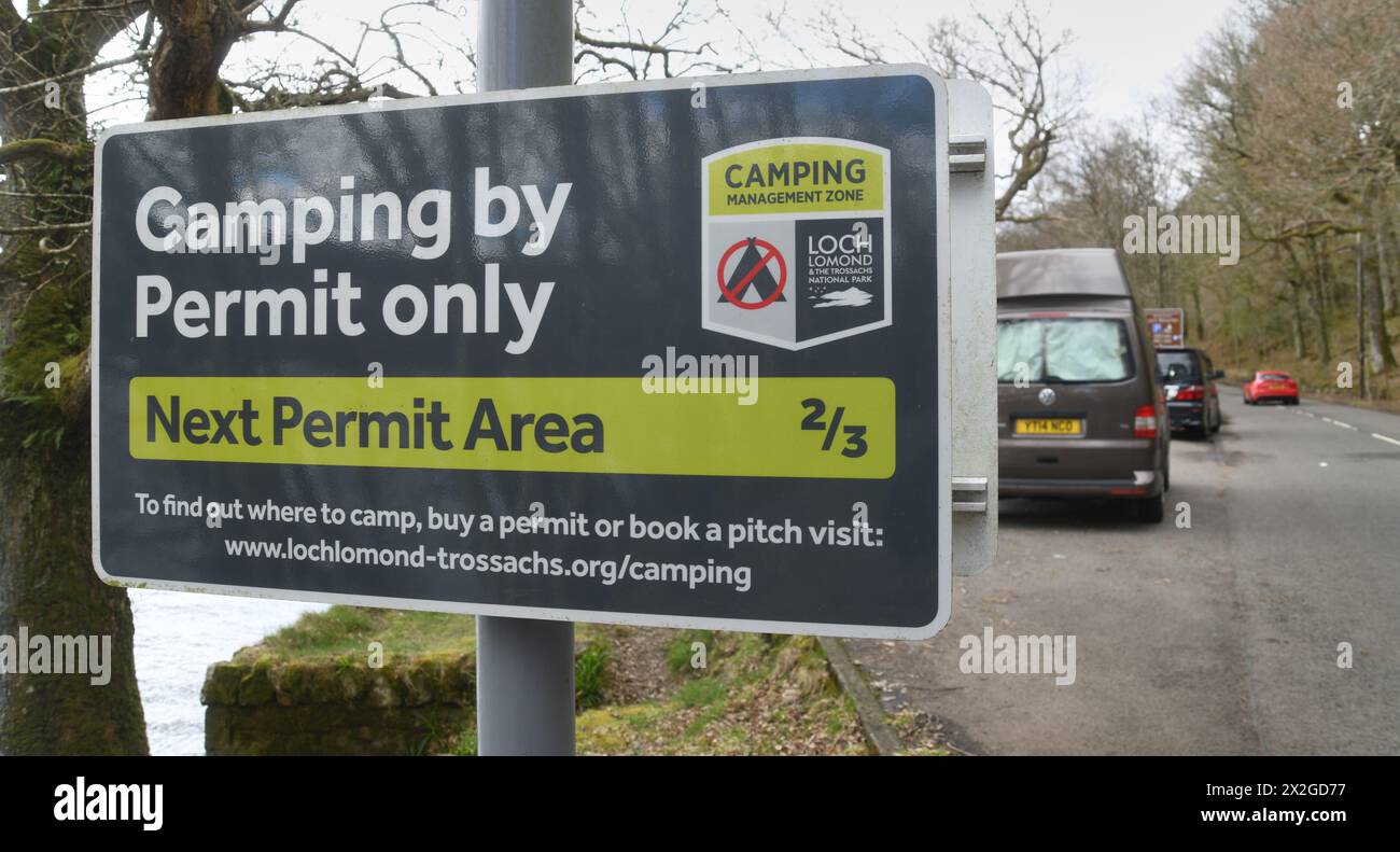 CAMPING BY PERMIT ONLY SIGN WITH CAMPERVANS AT LOCH VENACHAR IN THE LOCH LOMOND AND THE
