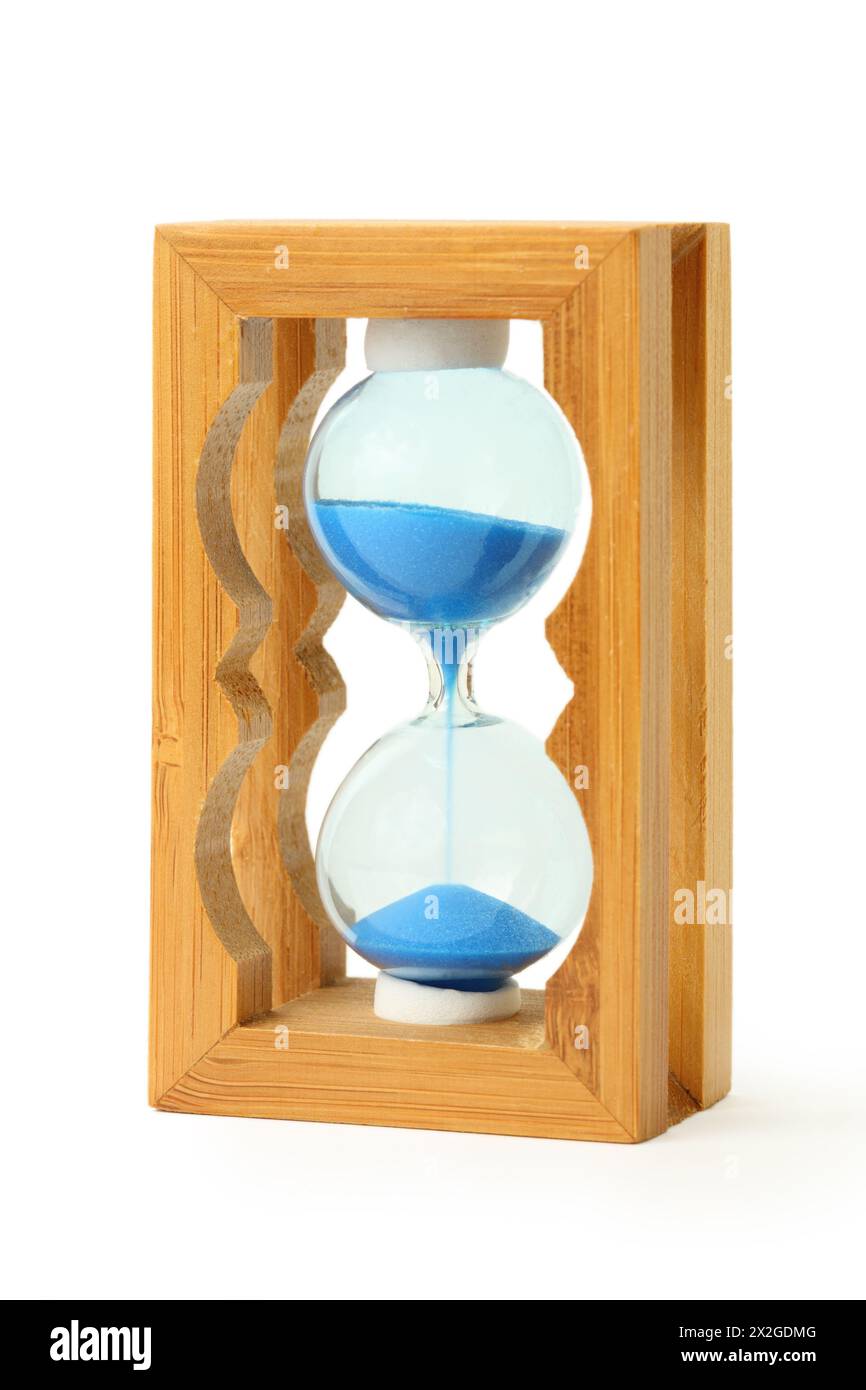 pure blue sand falls into wooden hourglass isolated on white Stock Photo