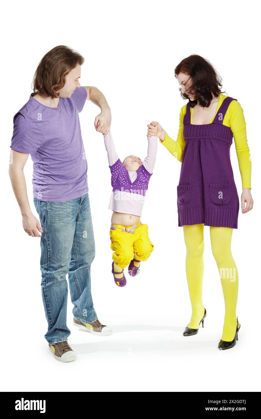 Father and mother swing by hands their little daughter. Stock Photo