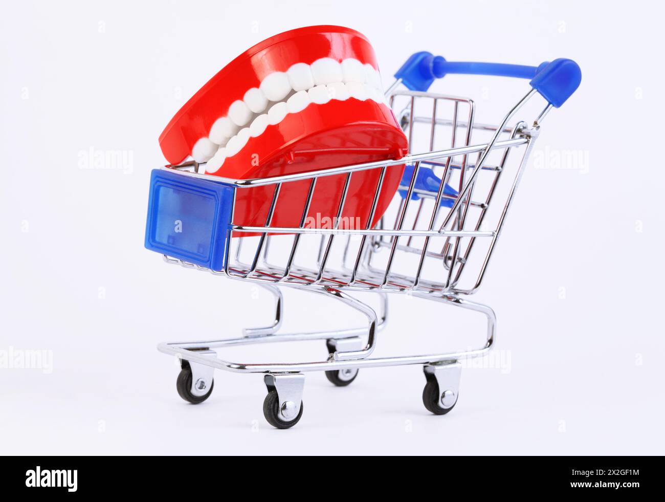 small toy jaw with white teeth in purchasing cart on white background Stock Photo