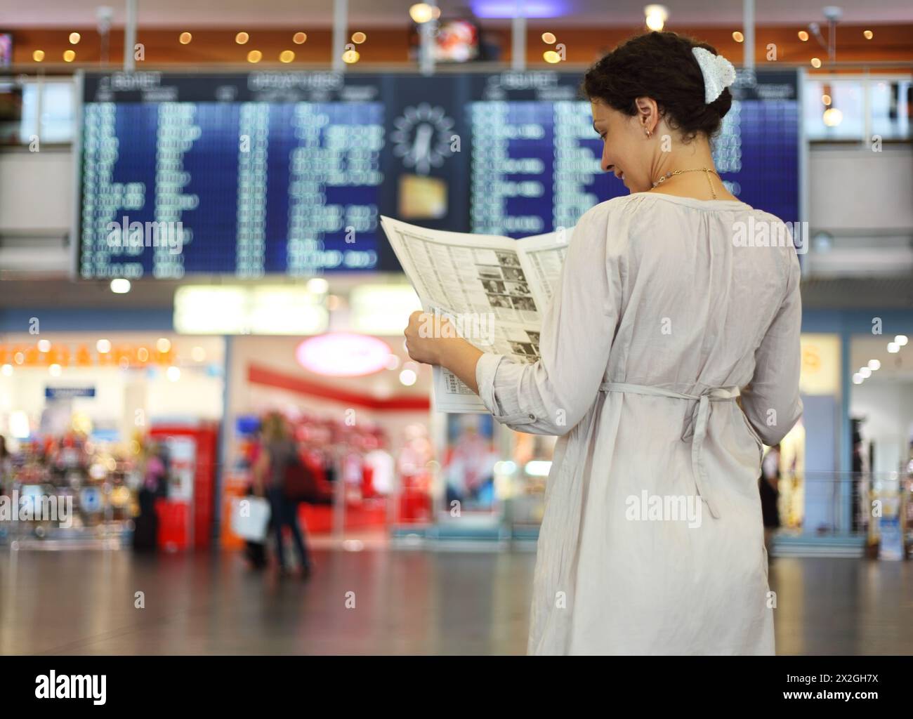 Woman reading in airport hi-res stock photography and images - Alamy