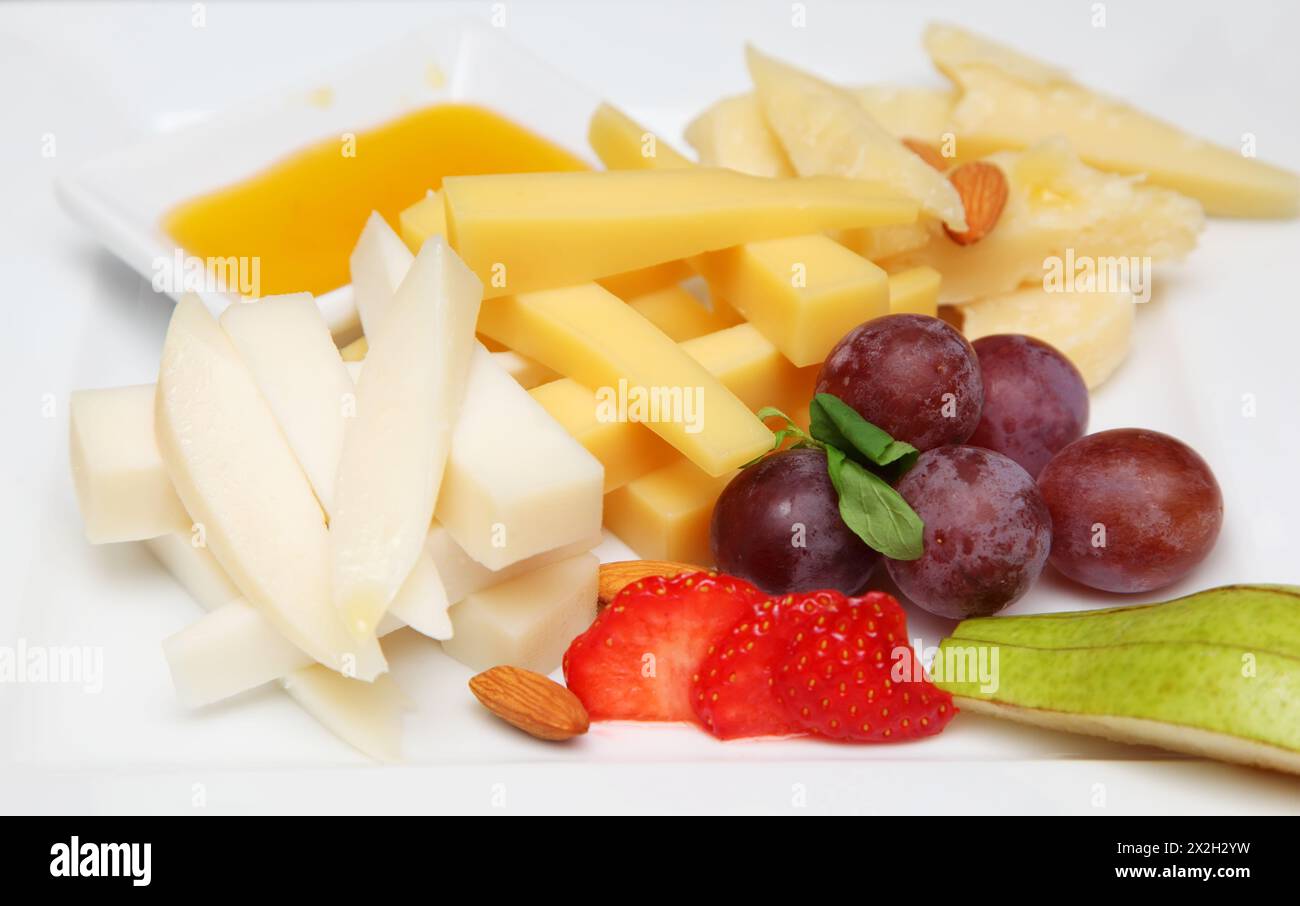Cold appetizers - cheese, sauce, grapes, pears, nuts, strawberries Stock Photo