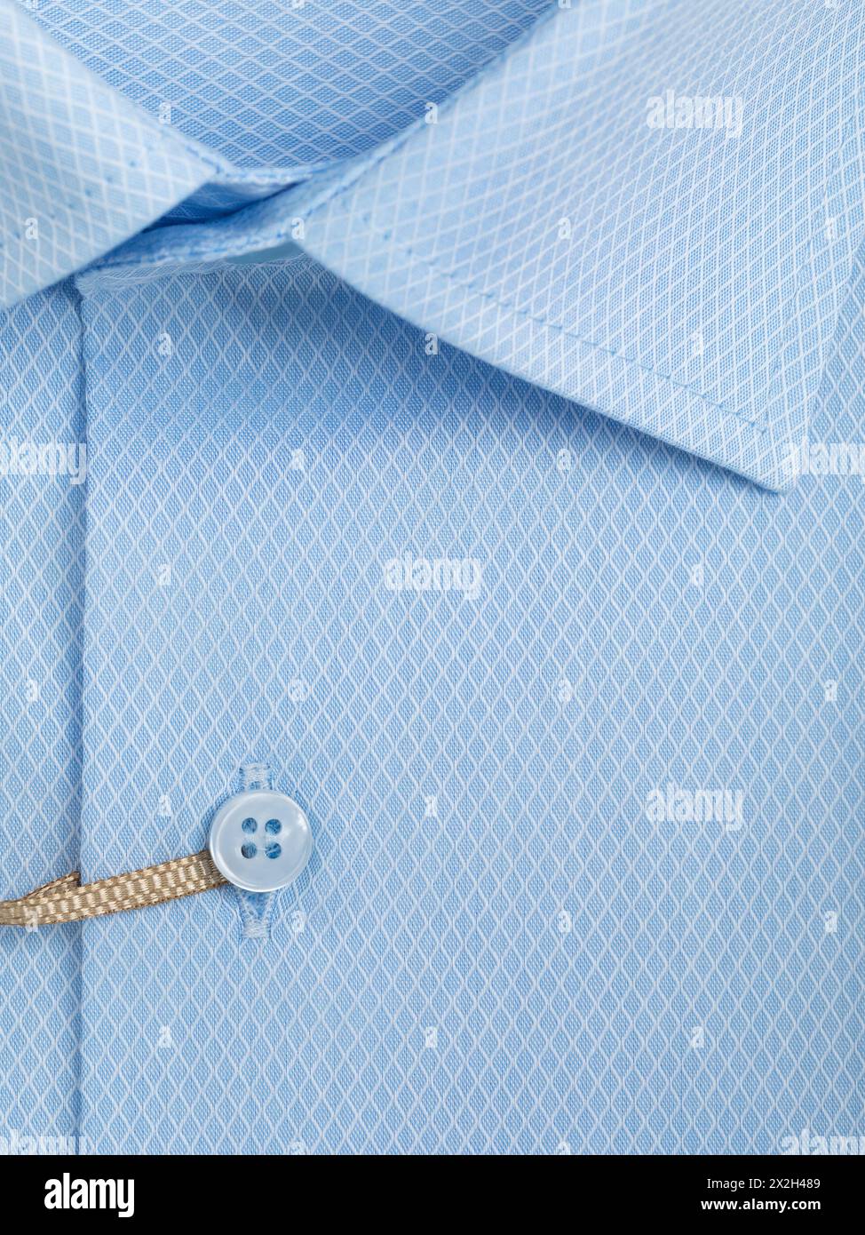 Close-up of a button placket on a light blue diamond shaped mesh shirt Stock Photo