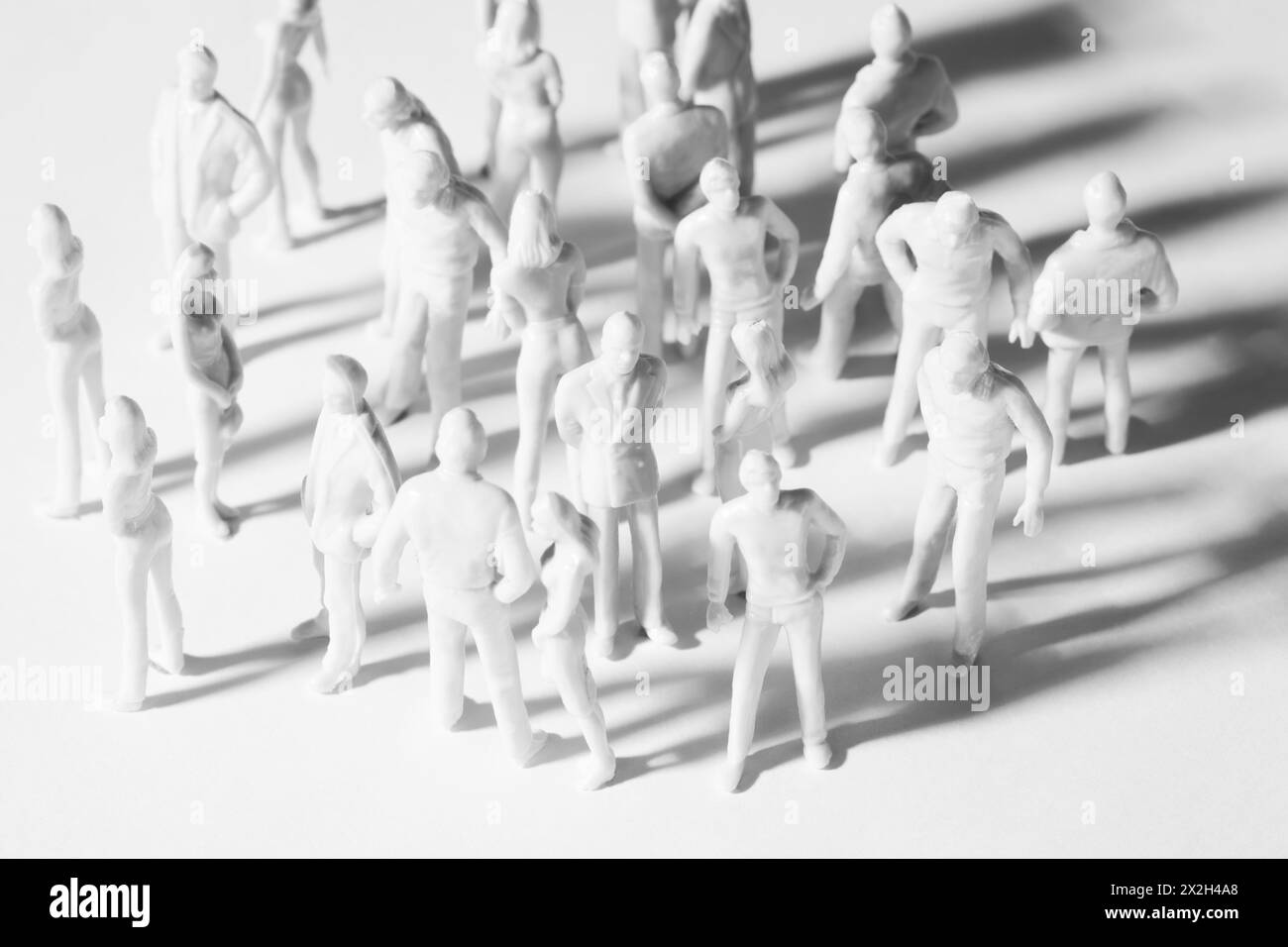 white miniature toy people stand in different poses, men and women