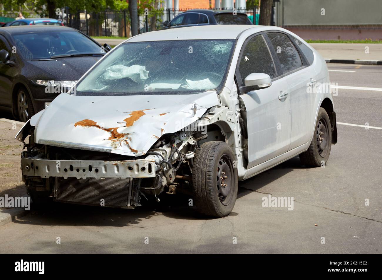 Car after an accident fallen out radiator, crumpled rusty hood