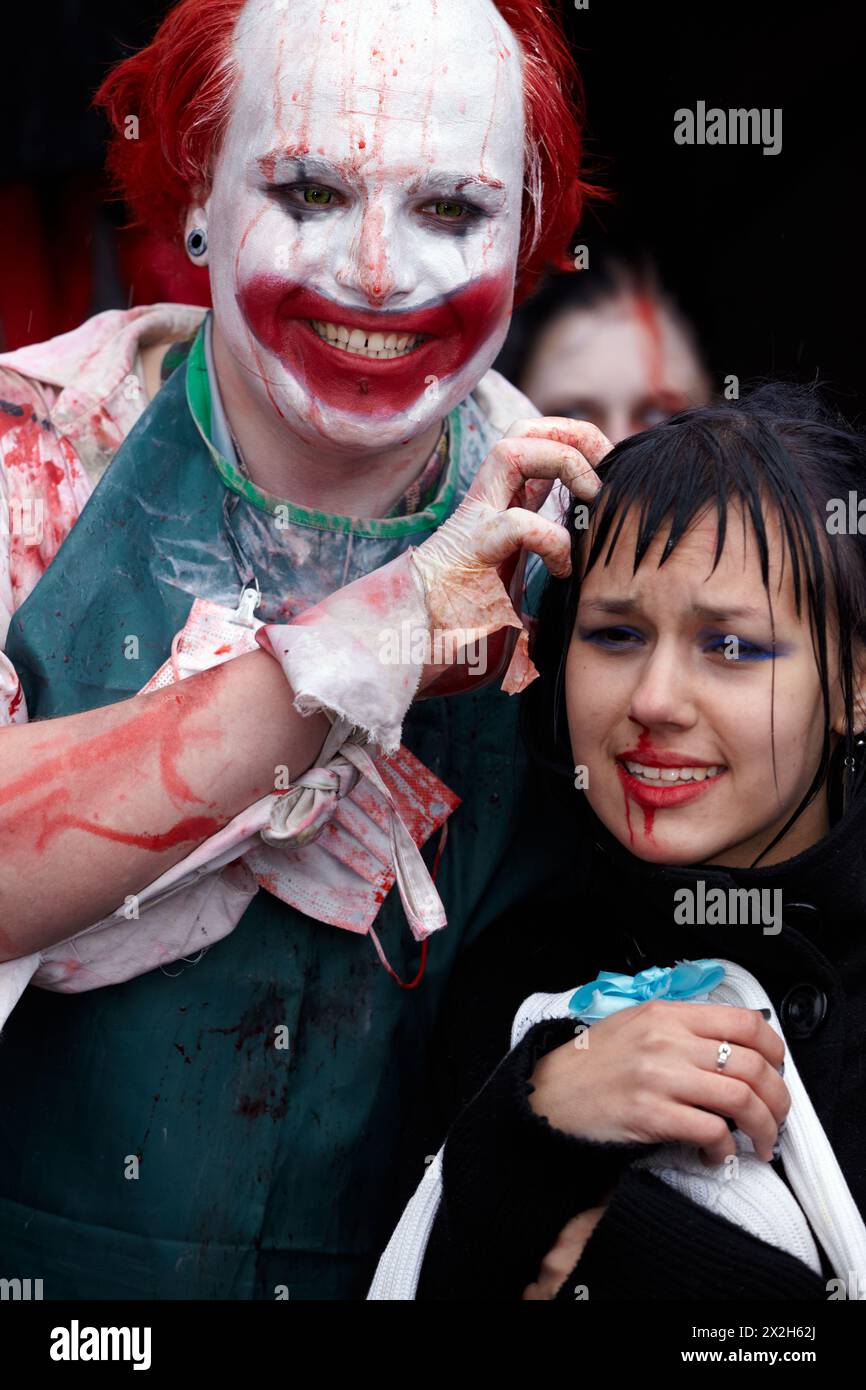 MOSCOW - MAY 14: Unidentified made-up participants - red-haired grinning clown with bloody face and crying girl - at Zombie Parade on Old Arbat, May 1 Stock Photo