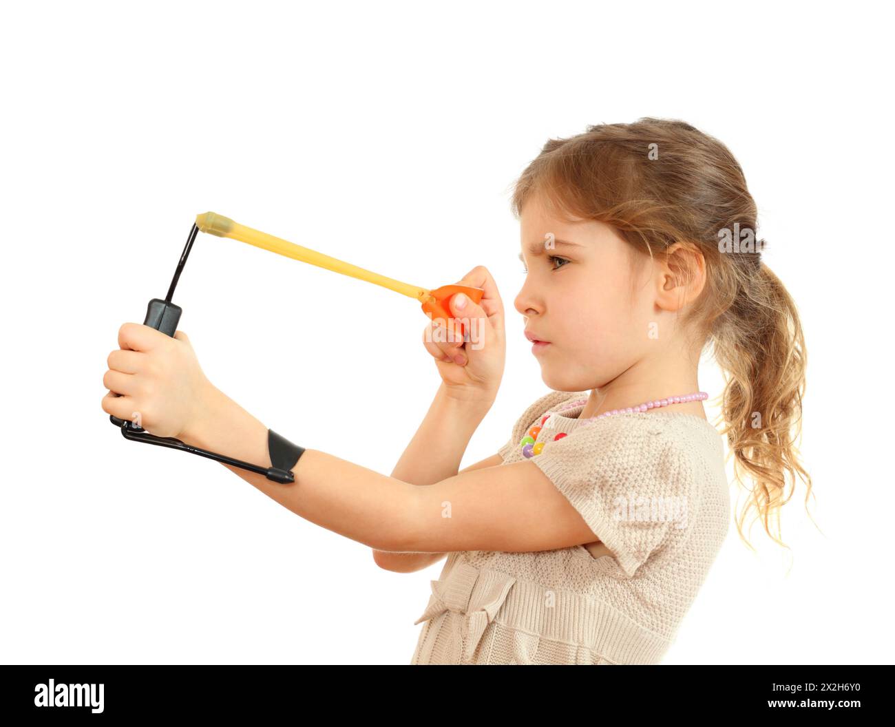 Concentrated girl with slingshot aim isolated on white background Stock Photo