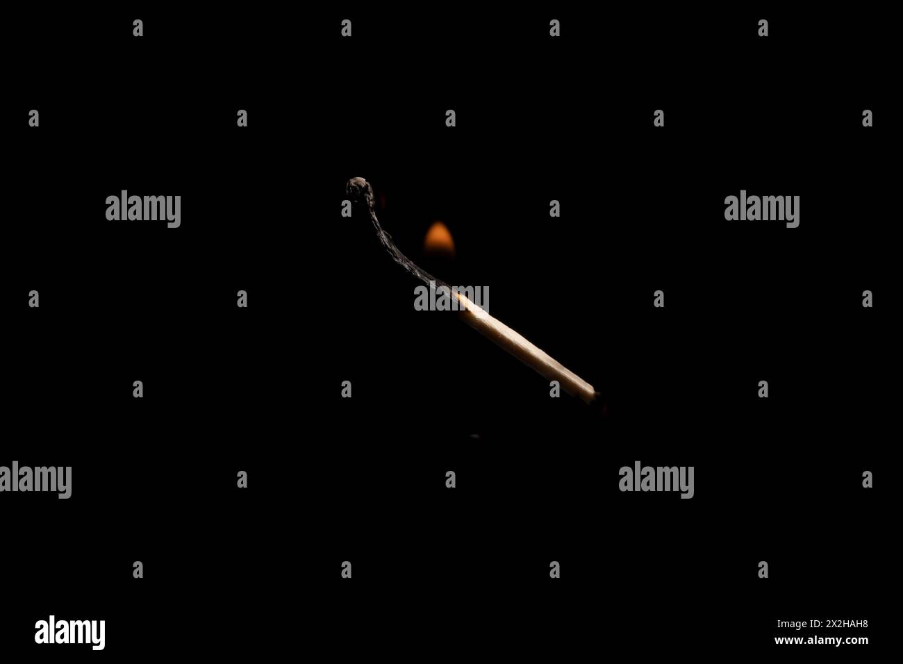 Lit and falling match on a black background. Stock Photo