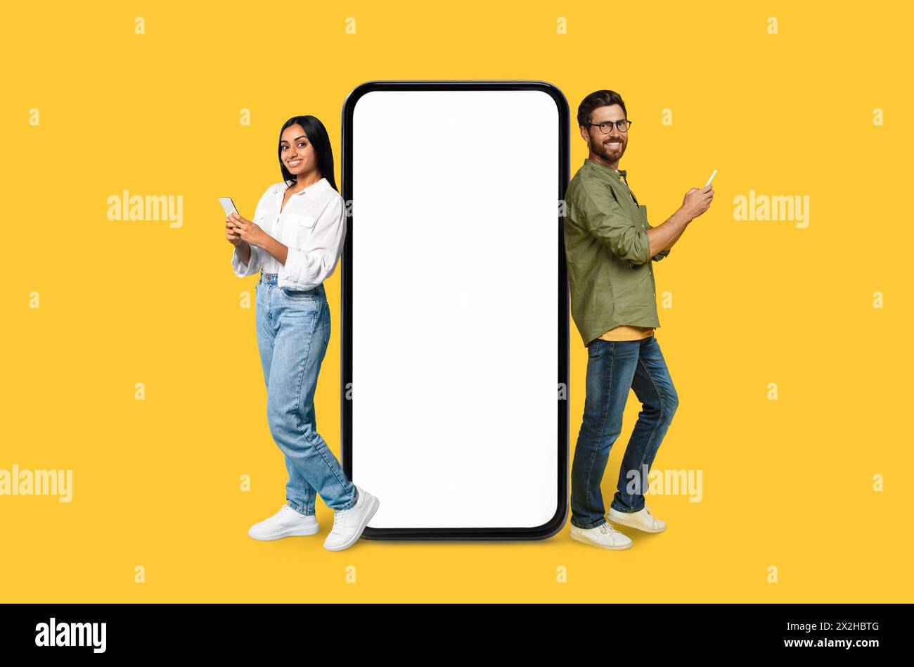 Two Multiracial people using phones next to mockup screen Stock Photo