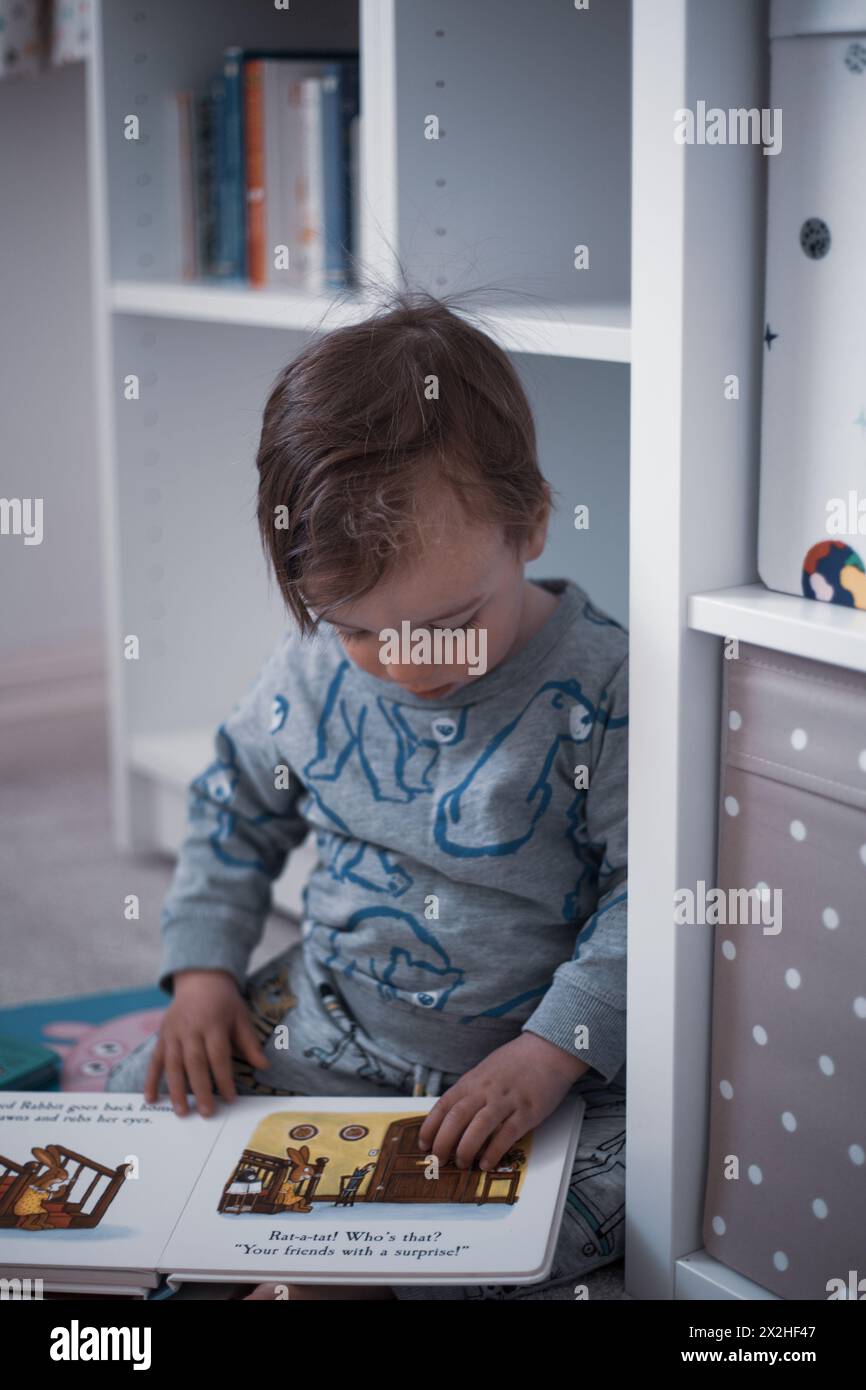 A heartwarming scene captures a 2-year-old boy riding his bedtime story. Stock Photo