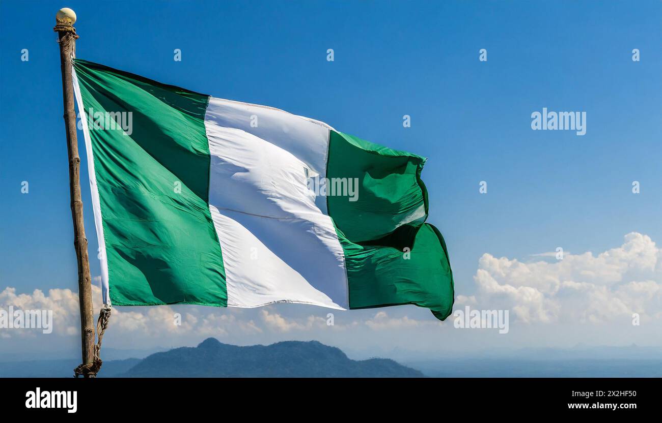 Die Fahne von Nigeria flattert im Wind, isoliert gegen blauer Himmel Stock Photo
