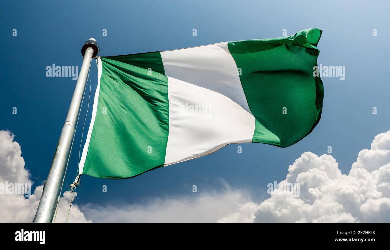 Die Fahne von Nigeria flattert im Wind, isoliert gegen blauer Himmel Stock Photo