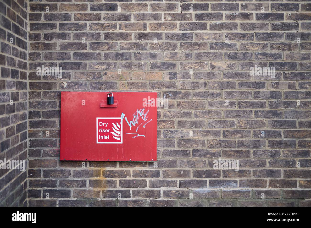 20 apr 2024 - londonuk : dry riser inlet with graffiti on brick wall Stock Photo
