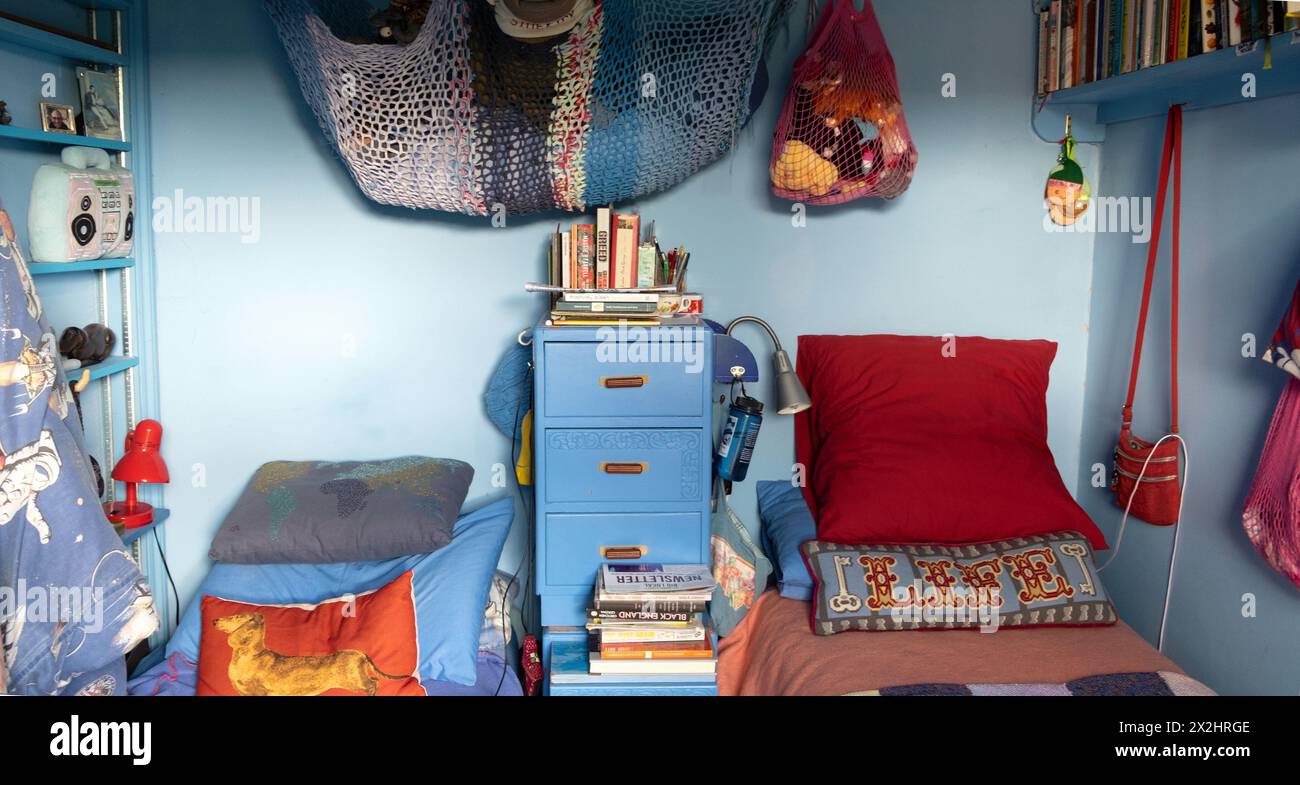 Domestic interior room elderly couple 's person quirky tidy blue bedroom beds pillows cushions net in London home UK Great Britain  KATHY DEWITT Stock Photo