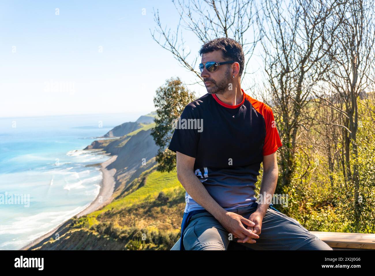 Portrait of a man looking at the beautiful coastal landscape in the flysch of Zumaia, Gipuzkoa. Basque Country Stock Photo