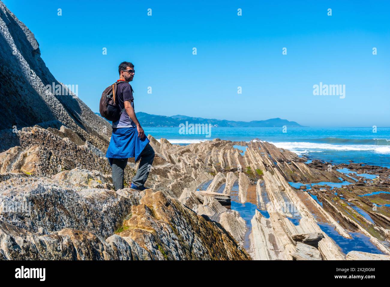 A hiker in the Flysch Basque Coast geopark in Zumaia, Gipuzkoa Stock Photo