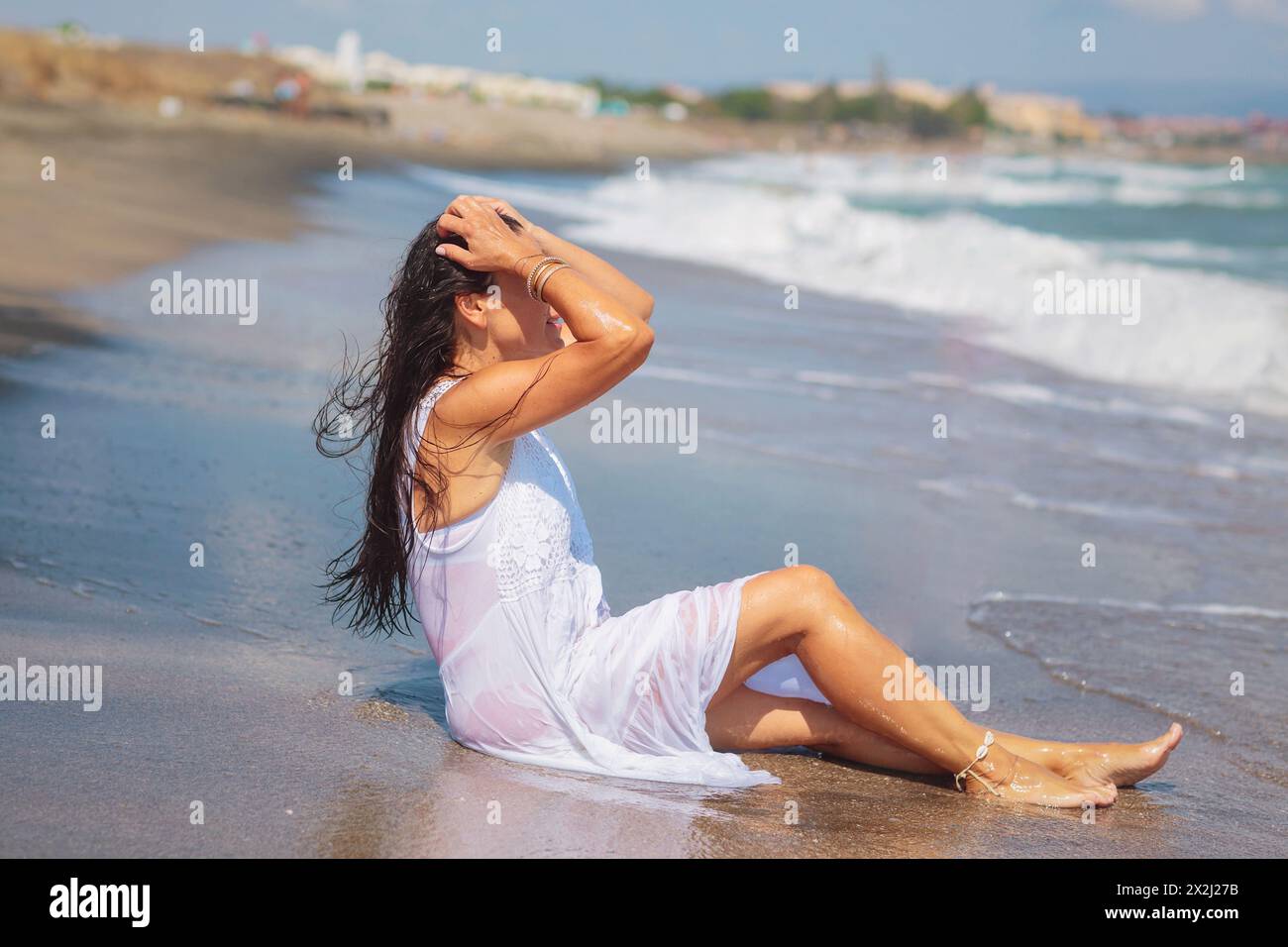 Happy mature woman in wet white dress sitting on sandy shore Stock Photo - Alamy Happy mature woman in wet white dress sitting on sandy shore Stock Photo - Alamy