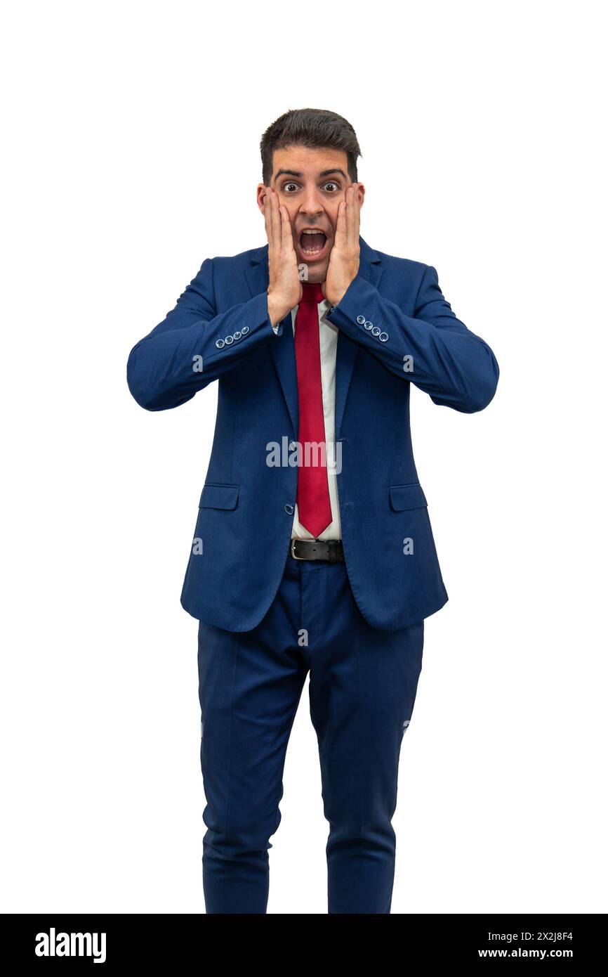 vertical businessman stands with his hands on his face, mouth agape, displaying a vivid expression of surprise. His eyes widened, reflecting a sudden Stock Photo