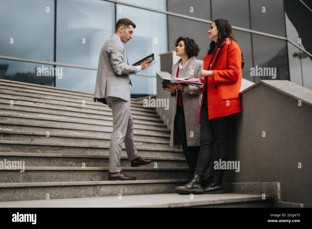 Business associates discussing strategy on office stairs outdoors Stock Photo