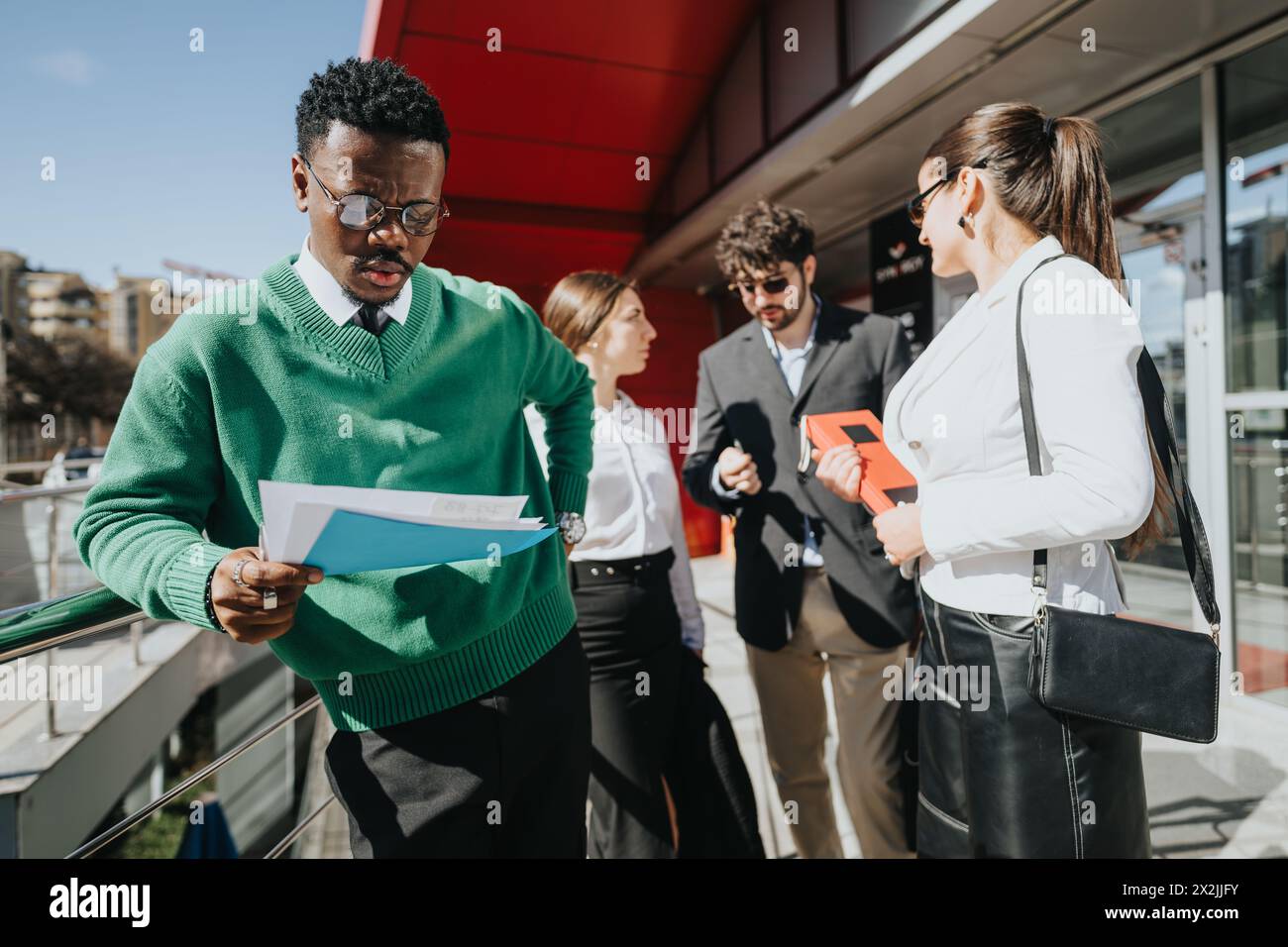 Business professionals discussing work outside on a sunny city day Stock Photo