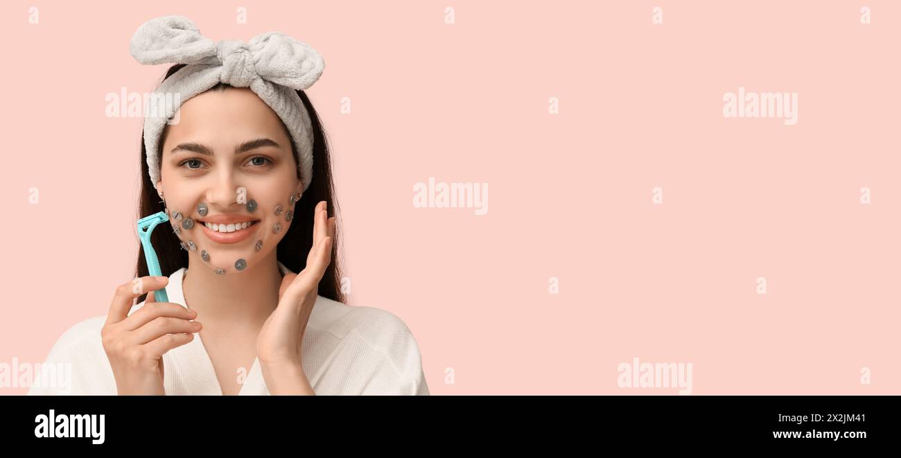 Young woman with thumb tacks on face and razor against pink background with space for text. Depilation concept Stock Photo