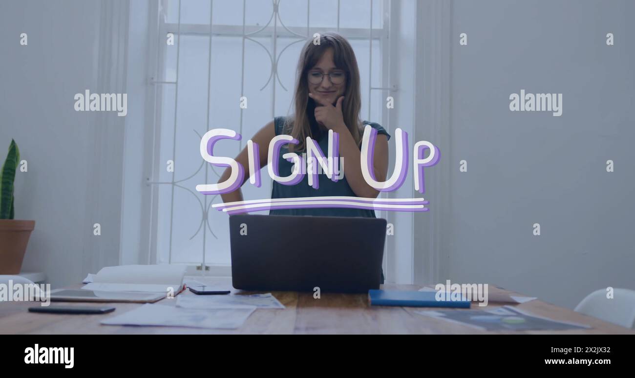 Image of sign up text over caucasian businesswoman using laptop in office Stock Photo