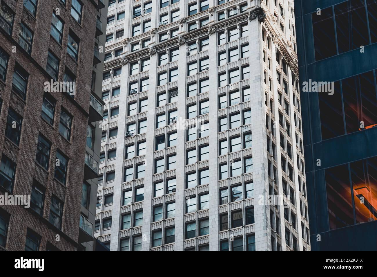 A detailed shot capturing contrasting architectural styles in a bustling urban downtown. The photo highlights textures and patterns of historical and Stock Photo