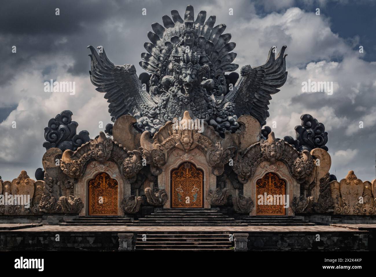 This image captures a majestic traditional temple adorned with intricate stone carvings, featuring mythical creatures and soaring designs against a dr Stock Photo