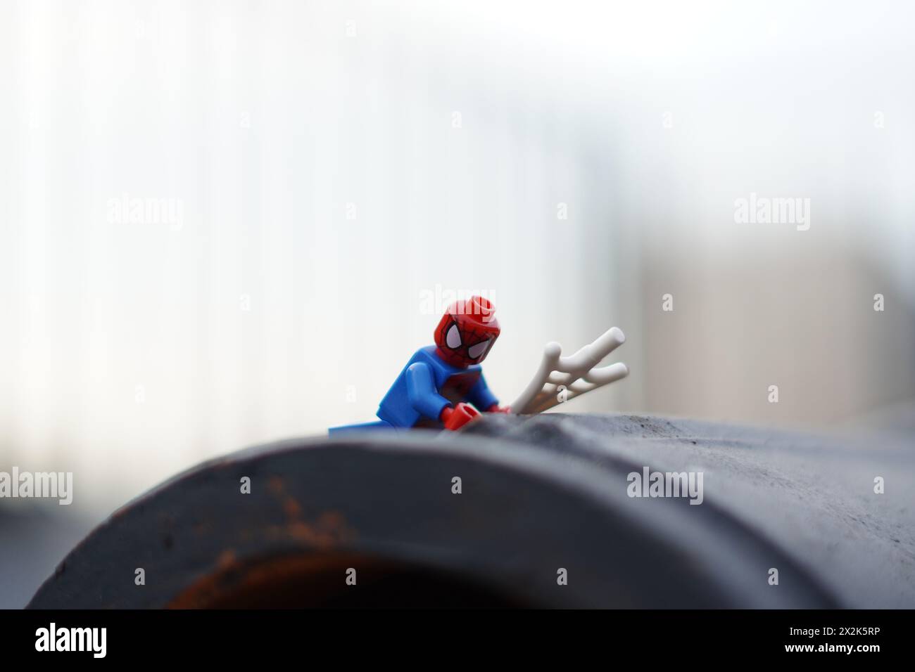Lego minifigure spiderman crawling up with blurred background and copy space Stock Photo