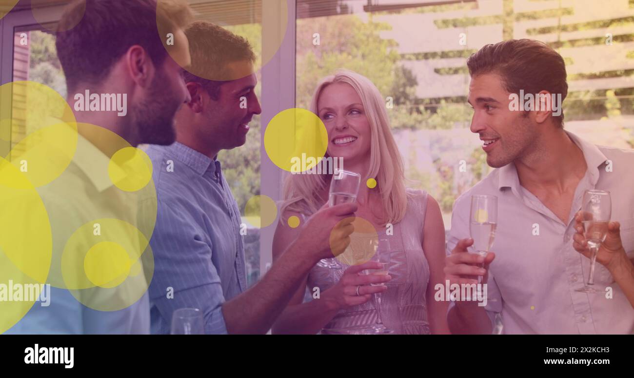 Image of yellow dots over happy caucasian female and male friends drinking wine and talking Stock Photo