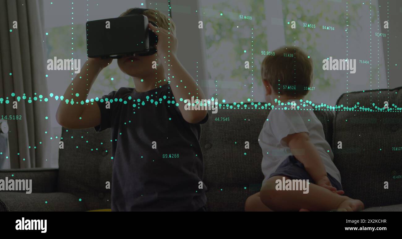 Image of financial data processing over boy using vr headset Stock Photo