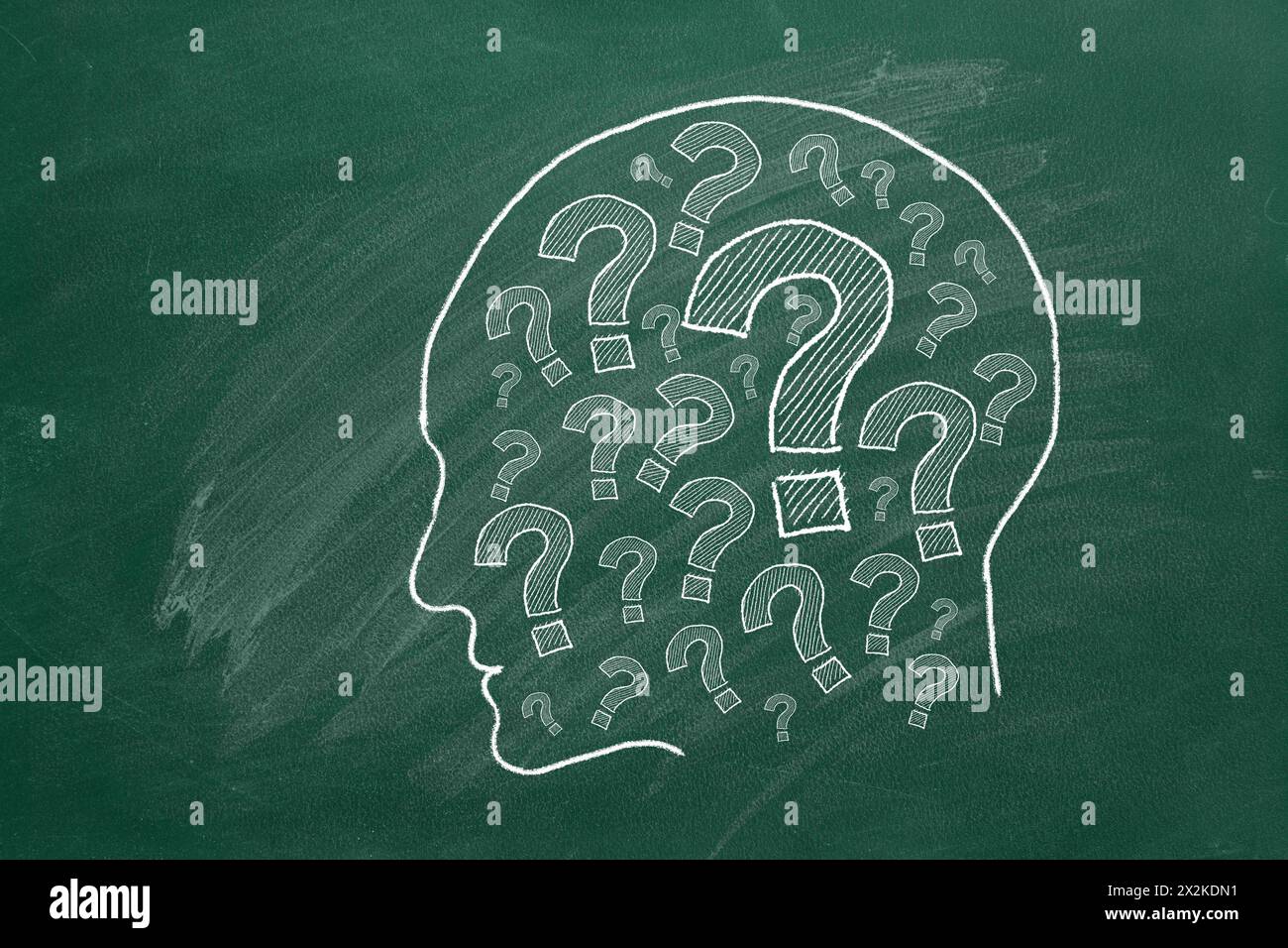 Human head with question marks inside. lustration on green chalkboard. Stock Photo