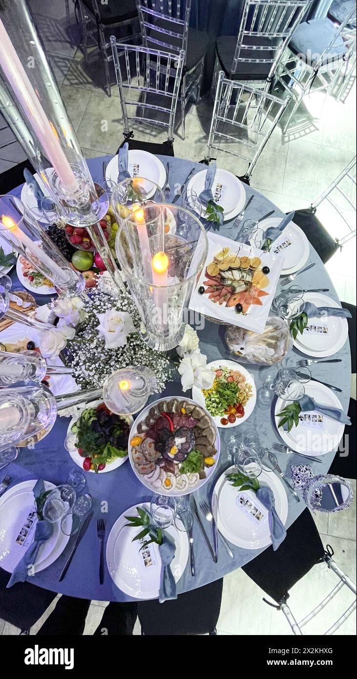 Table Setting Round Table Lavishly set round table with floral centerpiece, candles, and various ...