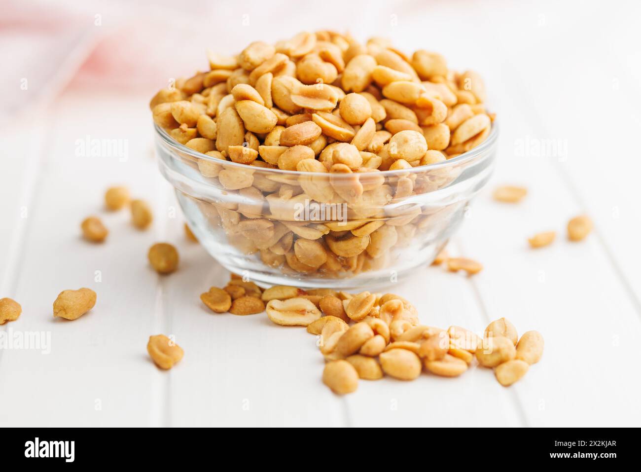 Salted roasted peanuts in bowl on a kitchen table Stock Photo