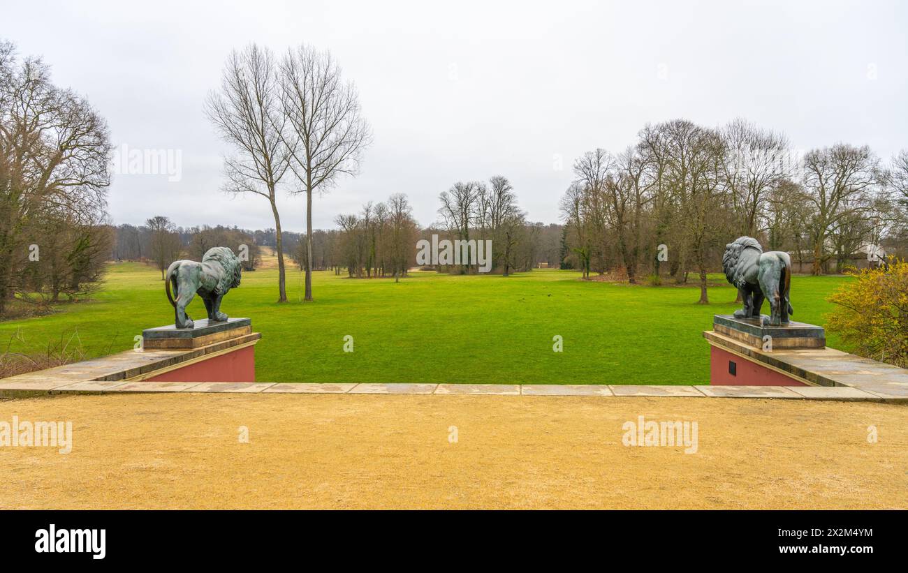 Overlooking a lush green lawn flanked by stone lion statues in Bad Muskau renowned park. Saxony, Germany Stock Photo
