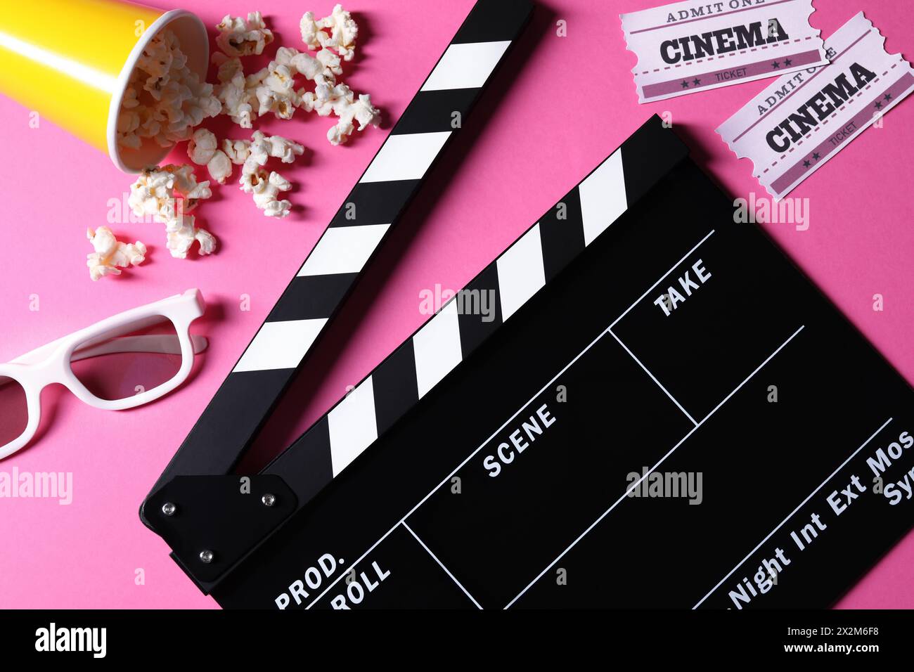 Flat lay composition with clapperboard and popcorn on pink background Stock Photo