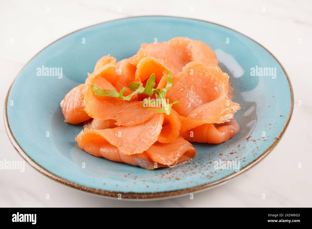 Smoked salmon on a blue plate on the white background Stock Photo